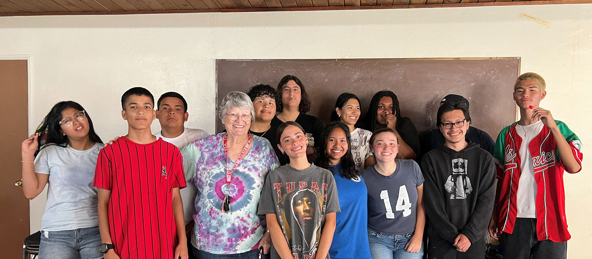 Sister wearing tie-dye shirt with a group of students