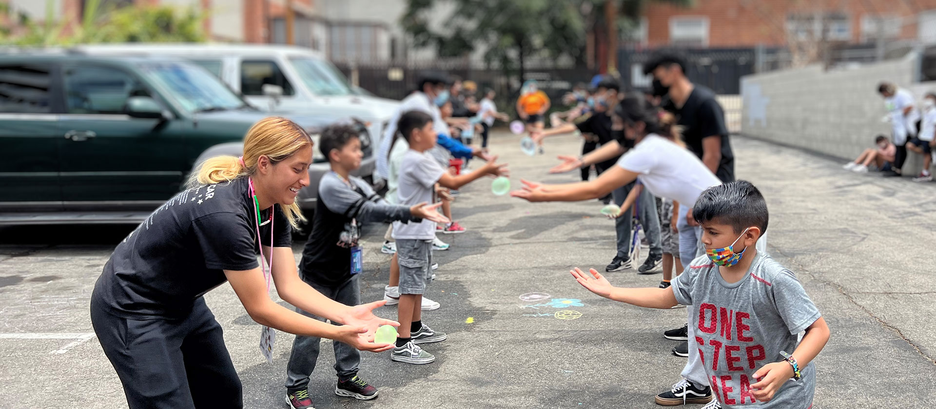 A game of water balloon toss with children at Regis House